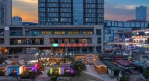 a view of a building in a city at night at Vienna Hotel Chongqing Yongchuan High-Speed Railway Station Xinglong Lake in Yongchuan