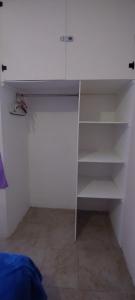 a room with a white closet with shelves at Bienvenidos a la casa gris in Tolentino