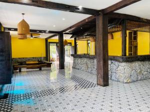 a room with a yellow wall and a tile floor at HaGiang Go Ecolodge in Làng Lap +2 photos