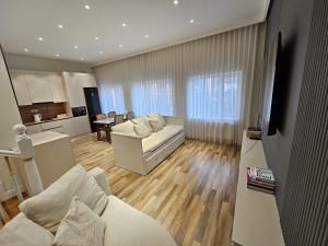 a living room with a white couch and a kitchen at Rooftop 1 Bedroom, Near City Center in Ulaanbaatar