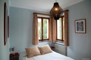 um quarto com uma cama e duas janelas em Villa Caroline em Waimes