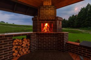 a brick outdoor fireplace with a pile of logs at Anupro Villa in Trakai