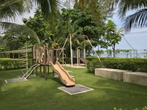 a playground with a slide in the grass at By The Sea with Side Seaview #363A in Batu Ferringhi
