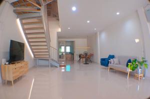 a living room with a couch and a staircase at Modern House CNX in Chiang Mai