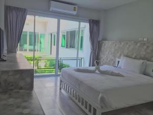 a bedroom with a large bed and a balcony at Kosit One Hotel in Ban Bung Sam Phan Nok