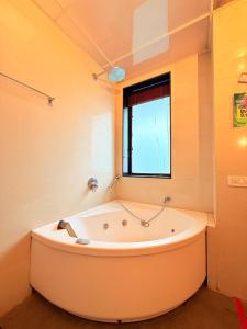 a large bath tub in a room with a window at Hilltop Hideaway Party Friendly 4BHK Pool Villa by Spacez in Mumbai +55 photos