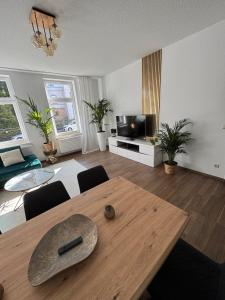 a living room with a wooden table and a television at Apartment Stadtperle in Gotha