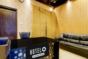 デヘラードゥーンにあるHotel O Dehradun City Centreのテーブルと革張りのソファがあるホテルの部屋
