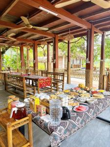 ein Tisch mit vielen Tellern voller Essen auf einer Terrasse in der Unterkunft Coconut Minh Tho Homestay in Mai Châu