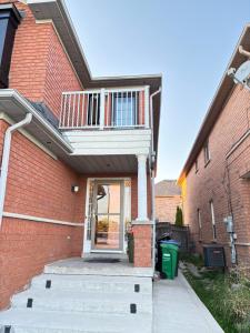 Cette maison en briques dispose d'un balcon. dans l'établissement Mississauga Guest House McDowell, à Mississauga