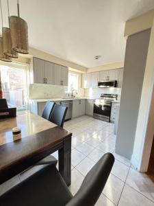 une cuisine avec une table et des chaises dans une pièce dans l'établissement Mississauga Guest House McDowell, à Mississauga