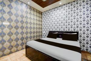 a bedroom with a bed and a wall at Super Hotel O Ambedkar Park Gorakhpur Formerly Mayur Residency in Gorakhpur