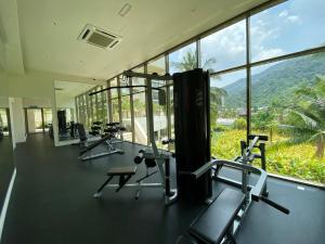 um ginásio com equipamento cardiovascular e uma grande janela em By The Sea Partial Seaview n Mountain View 383 em Batu Ferringhi