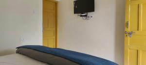 a bed with a blue pillow and a television at Valley vibes by Bahugunas den in Srīnagar +8 photos