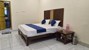 a bedroom with a bed with blue pillows and a table at Valley vibes by Bahugunas den in Srīnagar