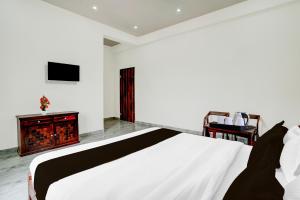 a bedroom with a white bed and a fireplace at Super Hotel O Mehta College And Institute Of Technology Formerly Lara Heritage in Jaipur