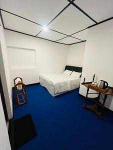 a bedroom with a bed and a blue carpet at The Crowns Lodge in Nuwara Eliya