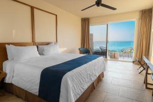 a bedroom with a bed and a view of the ocean at Wyndham Tamarindo in Tamarindo