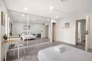 a white bedroom with a bed and a mirror at Sleek & Comfortable Ensuite Double Room at Revesby with Shared Kitchen in Revesby
