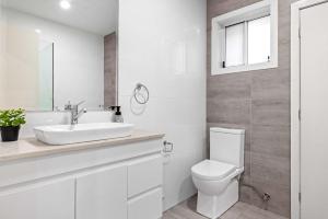 a white bathroom with a toilet and a sink at Sleek & Comfortable Double Room at Revesby with Shared Amenities in Revesby
