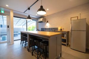 a kitchen with a bar with stools and a refrigerator at mion in Kyonan