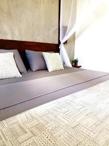 a bed with two pillows on it in a room at Surface Stay and Café in Tangalle