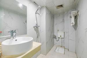 a white bathroom with a sink and a shower at JUNYI Hotel Jiangxi Xinyu Baoshi Park in Xinyu