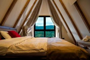 a bedroom with a bed with a large window at Chalet Rafenstein in Moisei +79 photos