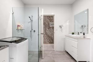 a white bathroom with a shower and a sink at Sleek & Comfortable Single Room at Revesby with Shared Amenities in Revesby +27 photos