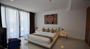 a bedroom with a large bed and a large window at Sansuri Resort in Surin Beach +89 photos