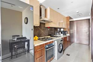迪拜Sardinia Hotel Mood-Dubai Downtown Hight Floor的厨房配有洗衣机、烘干机和桌子