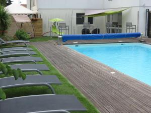 a swimming pool with lounge chairs and an inflatable at Le Parasol in Ars-en-Ré