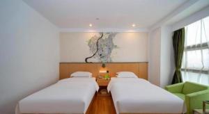 a room with two beds and a desk and a window at Vatica Hefei Feidong County Yuzhou Central Square Hotel in Hefei +225 photos