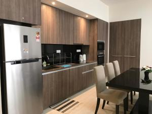 a kitchen with a dining table and a refrigerator at By The Sea Cozy Beachfront Home 253 in Batu Ferringhi