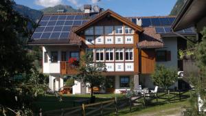 une maison avec des panneaux solaires sur son toit dans l'établissement Casa Guido e Laura, à Pozza di Fassa