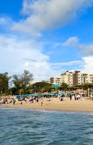 a beach with a bunch of people on it at By The Sea Cozy Beachfront Home 253 in Batu Ferringhi