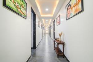 un pasillo con paredes blancas y un largo pasillo con pinturas en las paredes en FabHotel Prime Adhirath Grand-Nr Madhapur-Hitech CIty, en Hyderabad