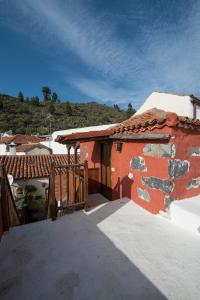 a balcony of a red house with a roof at Casa Vidal in Guía de Isora