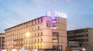 a building with a sign on the top of it at 7 Days Inn Luoyang Railway Station Wangcheng Avenue in Luoyang
