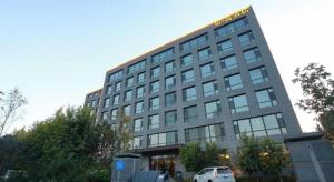 a building with a car parked in front of it at Harbin Ju Jian Hotel in Harbin