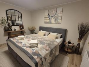 a bedroom with a large bed with towels on it at Ferienhaus im Heideparadies Handeloh-Höckel in Handeloh