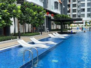 Kampong TangihanにあるTF Luxe Suites K Avenue Kepayanの白い椅子付きのスイミングプール