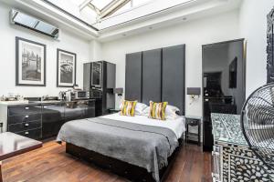 a bedroom with a large bed and a sink at Strozzi Palace Suites by Mansley in Cheltenham