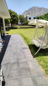 une chaise blanche posée sur l'herbe à côté d'un trottoir dans l'établissement La Casita de Condoray - Lunahuana, à Lunahuaná