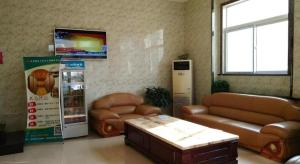 a living room with two leather couches and a tv at Shell Hotel Taiyuan South Railway Station New Southeast Bus Station in Taiyuan
