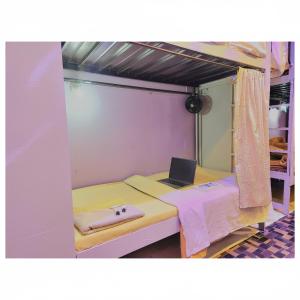 une chambre avec un lit superposé avec un ordinateur portable dessus dans l'établissement goldenstar deluxe dormitory, à Mumbai