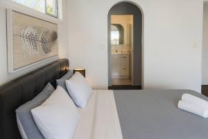 a bedroom with a large bed with white pillows at Stillwater Getaway - Waterfront House with Pontoon in Gold Coast +26 photos
