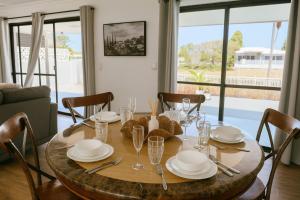 a wooden table with plates and glasses on top of it at Stillwater Getaway - Waterfront House with Pontoon in Gold Coast