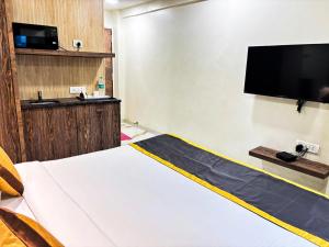 a room with a bed and a flat screen tv at TIM Santacruz Mumbai Airport in Mumbai