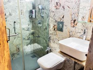 a bathroom with a shower and a sink and a toilet at TIM Santacruz Mumbai Airport in Mumbai